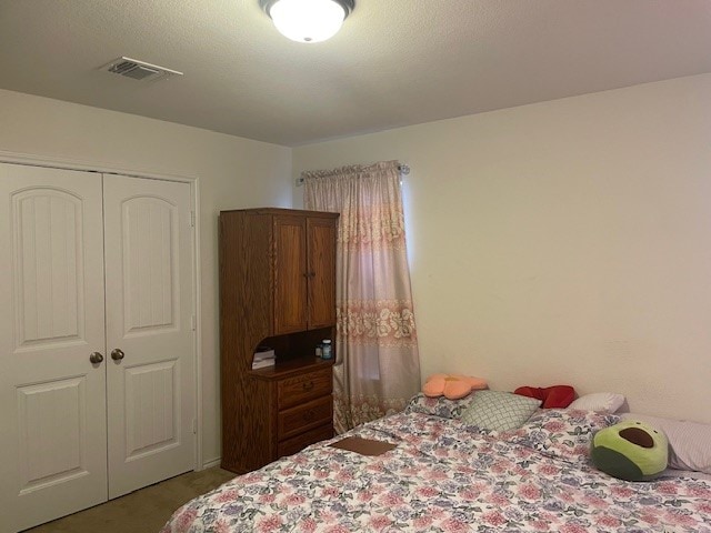 bedroom with carpet flooring, a textured ceiling, and a closet