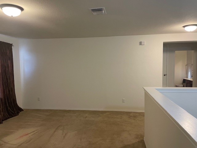 carpeted spare room with a textured ceiling