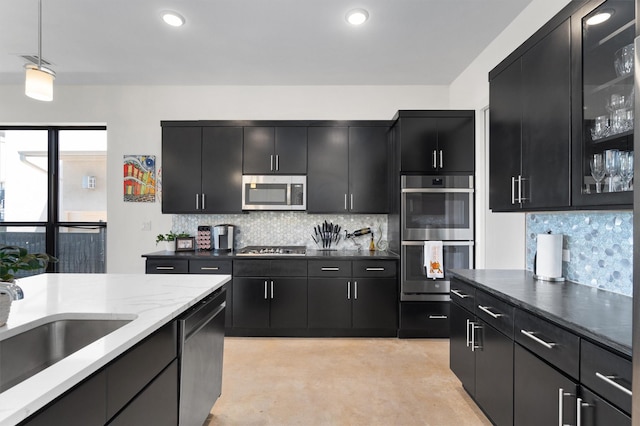 kitchen featuring stainless steel appliances, tasteful backsplash, sink, and pendant lighting