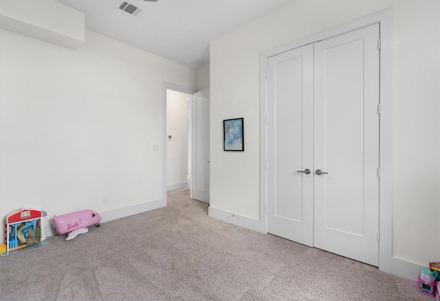 unfurnished bedroom with light carpet and a closet