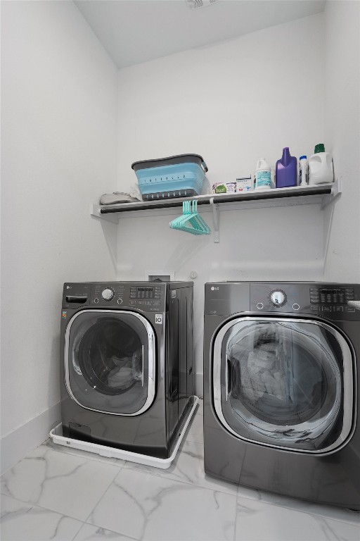 clothes washing area with washing machine and dryer