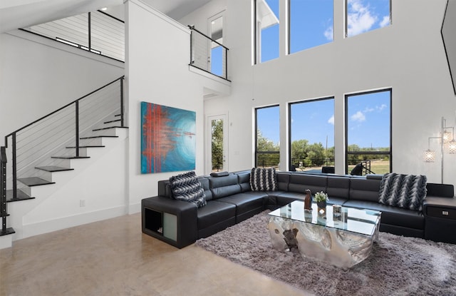 living room with concrete floors, a healthy amount of sunlight, and a high ceiling