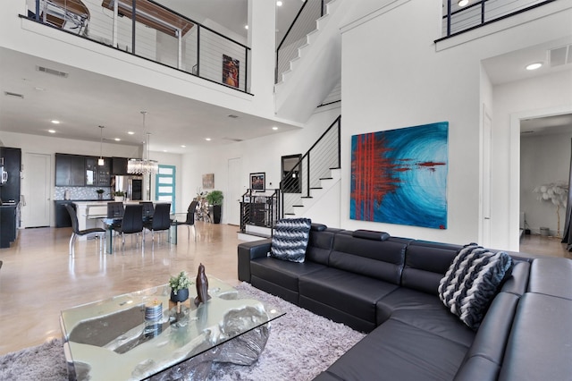 living room with a notable chandelier and a high ceiling