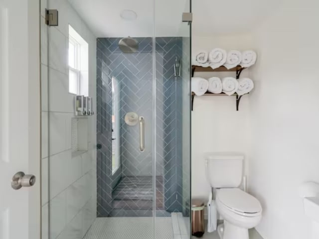 bathroom featuring tile patterned floors, an enclosed shower, and toilet