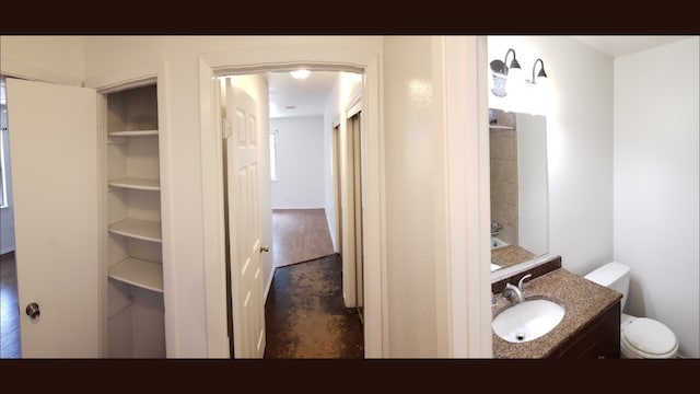 bathroom featuring vanity, wood-type flooring, and toilet