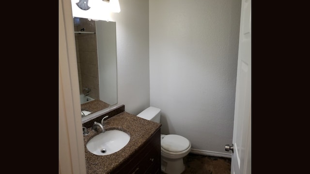 bathroom with vanity, toilet, and a tile shower