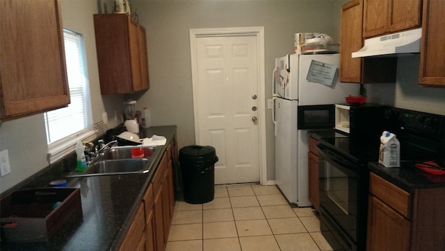 kitchen featuring light tile patterned floors, white refrigerator, black electric range oven, and sink