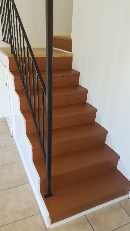 stairway with tile patterned floors