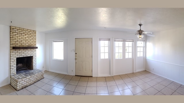 entryway with a fireplace, light tile patterned floors, and a wealth of natural light