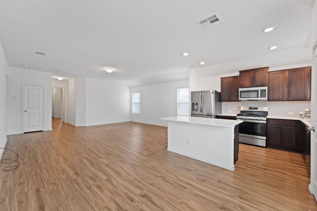 kitchen with light hardwood / wood-style flooring, a center island, dark brown cabinets, and appliances with stainless steel finishes