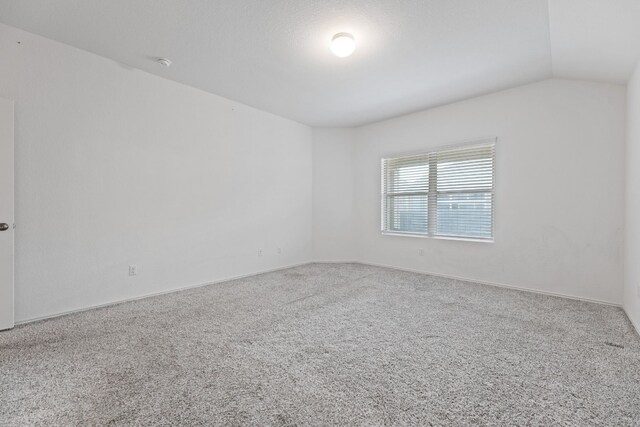 unfurnished room with carpet flooring and lofted ceiling