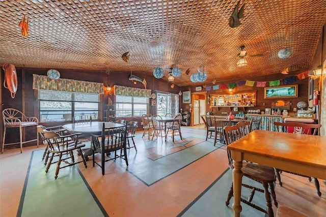 dining space featuring brick ceiling, concrete floors, and lofted ceiling