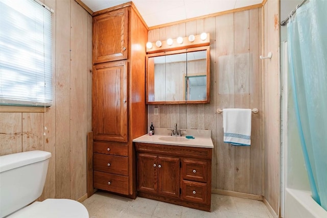 full bathroom with vanity, toilet, and wooden walls