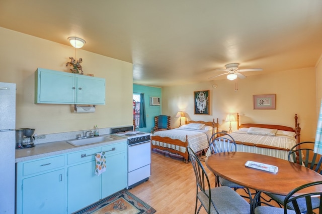 201 Lakewood Dr, Burnet, TX 78611 - kitchen featuring white appliances, a ceiling fan, light countertops, light wood-style flooring, and blue cabinets