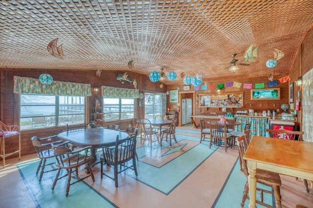 201 Lakewood Dr, Burnet, TX 78611 - dining area with vaulted ceiling, wooden walls, and concrete flooring