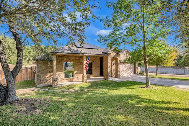 view of front of house featuring a front yard, solar panels, and a garage