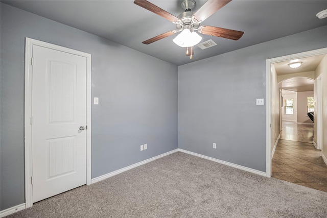 carpeted spare room with ceiling fan