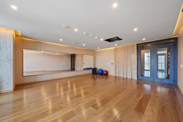 exercise room featuring french doors and light hardwood / wood-style floors