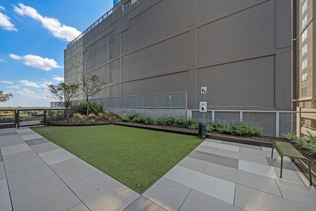 surrounding community featuring a lawn and basketball hoop