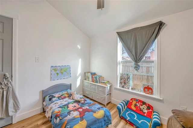 bedroom featuring light wood-type flooring, vaulted ceiling, and ceiling fan