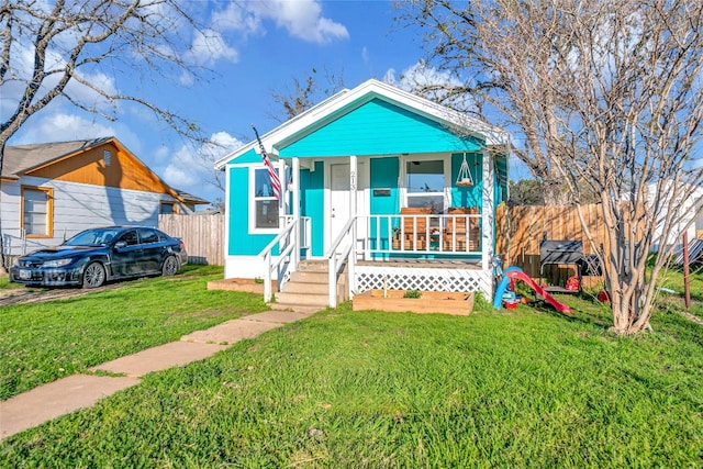 bungalow with covered porch and a front yard