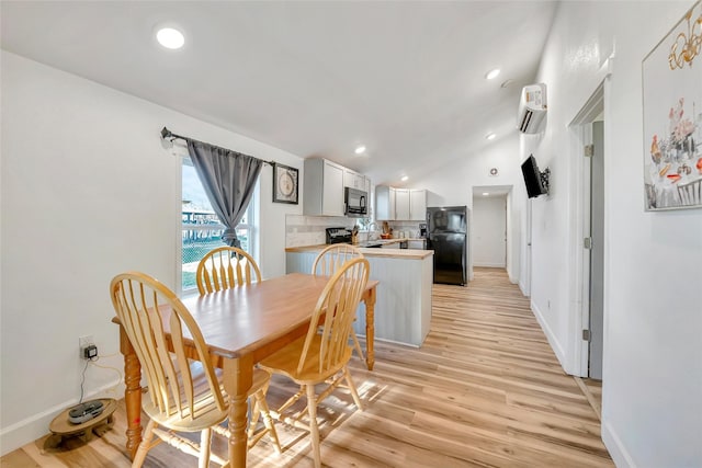 dining area featuring light hardwood / wood-style flooring and vaulted ceiling