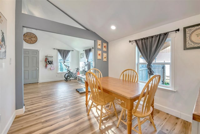 dining room featuring light hardwood / wood-style floors and lofted ceiling