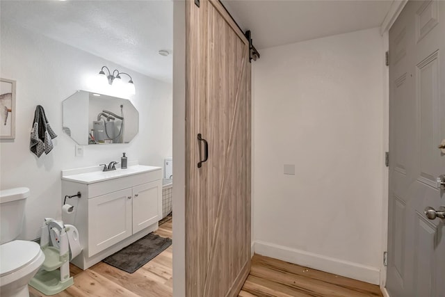 bathroom featuring hardwood / wood-style flooring, vanity, and toilet