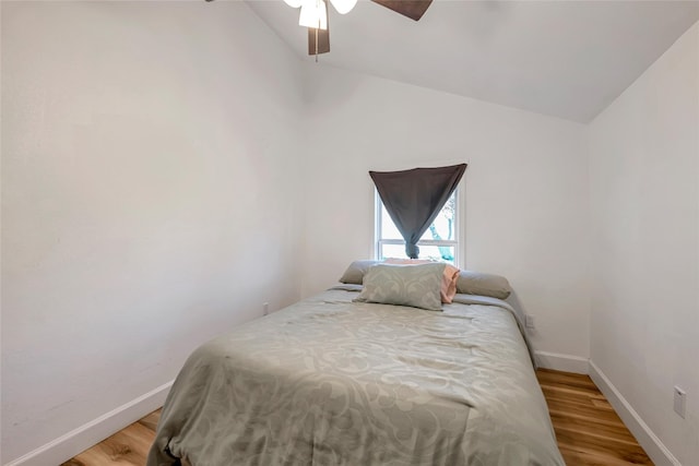 bedroom with ceiling fan, vaulted ceiling, and hardwood / wood-style flooring