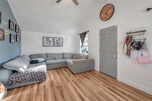 living room with ceiling fan, vaulted ceiling, and light hardwood / wood-style flooring