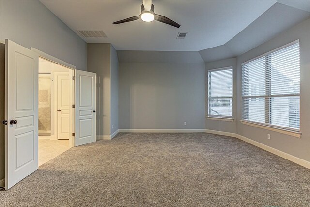 unfurnished bedroom featuring ceiling fan, light carpet, and vaulted ceiling