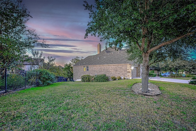 property exterior at dusk with a lawn