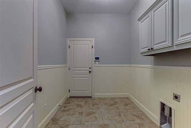 washroom with electric dryer hookup and cabinets