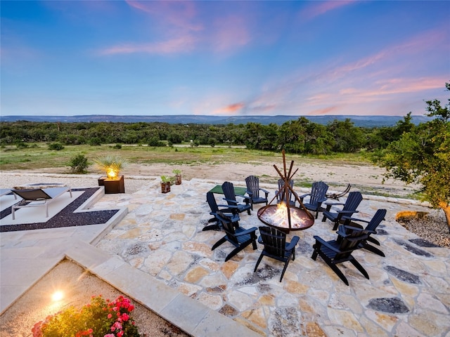 patio terrace at dusk featuring an outdoor fire pit