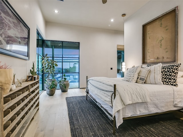 bedroom featuring access to exterior and hardwood / wood-style floors