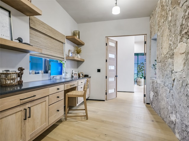 kitchen featuring decorative light fixtures, light hardwood / wood-style floors, and light brown cabinets