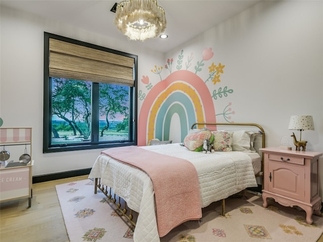 bedroom with a chandelier and light hardwood / wood-style floors