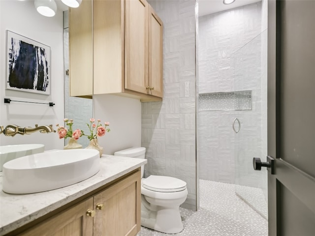 bathroom with tile patterned floors, vanity, toilet, and walk in shower