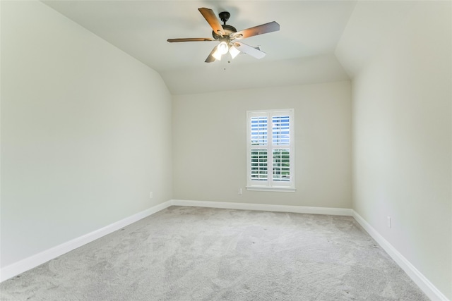 carpeted empty room with ceiling fan and vaulted ceiling