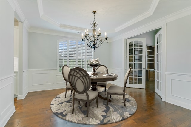 dining room with a notable chandelier, dark hardwood / wood-style floors, ornamental molding, and a tray ceiling