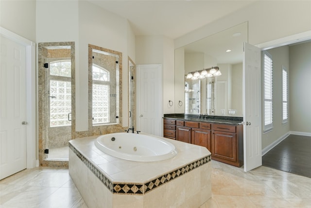 bathroom with tile patterned floors, vanity, plus walk in shower, and a healthy amount of sunlight