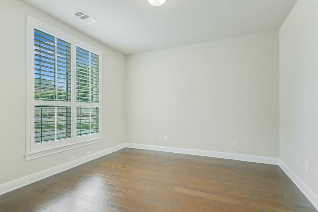empty room with dark wood-style floors and baseboards