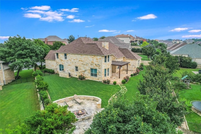 rear view of house featuring stone siding, a fire pit, a pergola, a patio, and a residential view