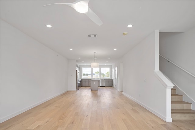 unfurnished living room featuring ceiling fan and light wood-type flooring