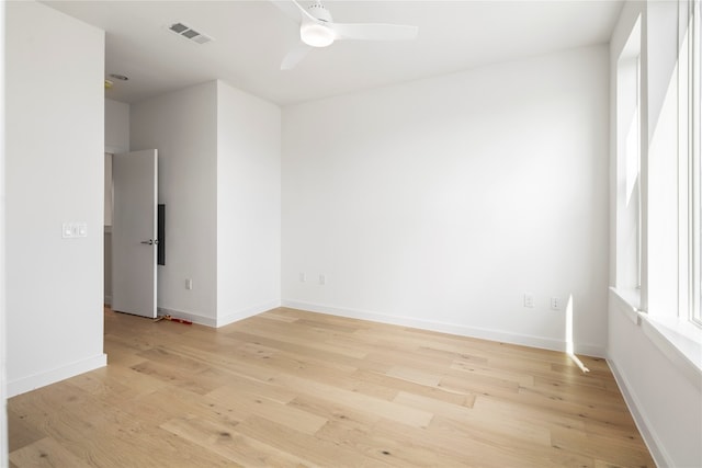 empty room with ceiling fan and light hardwood / wood-style floors