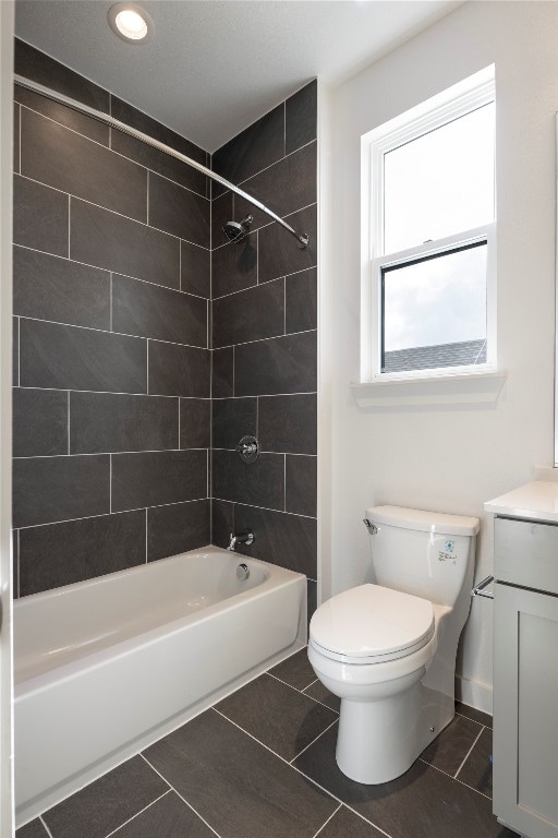 full bathroom featuring toilet, tile patterned flooring, vanity, and tiled shower / bath