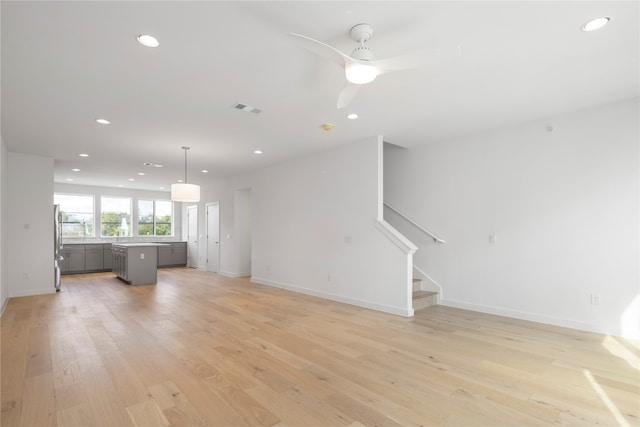 unfurnished living room featuring ceiling fan and light hardwood / wood-style flooring