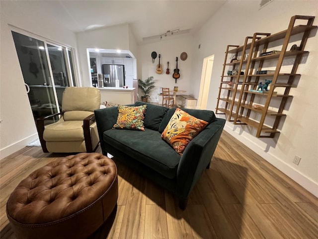 living room featuring wood-type flooring and lofted ceiling