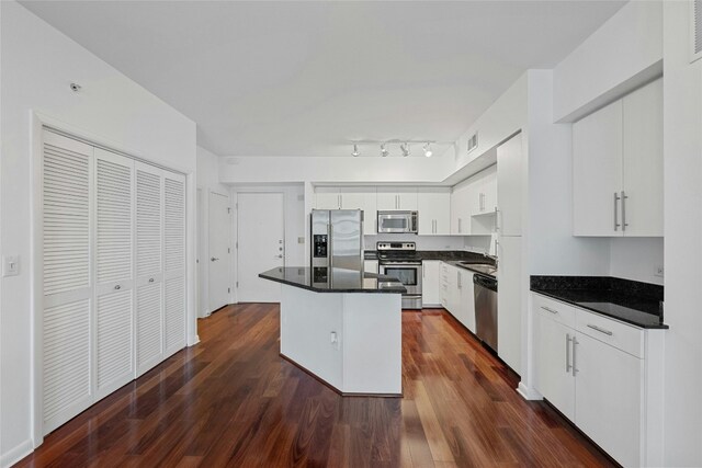 kitchen with sink, a center island, dark wood-type flooring, white cabinets, and appliances with stainless steel finishes