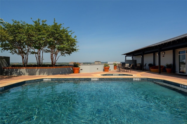 view of pool featuring a patio area and an in ground hot tub